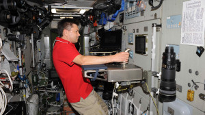 While the International Space Station (ISS) flies over Europe, cosmonaut Oleg Kononenko controls the German Aerospace Center’s ROKVISS robot in a laboratory in Oberpfaffenhofen with the Kontur-2 joystick. Credit: ROSKOSMOS /O. Kononenko. 