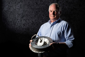 Jim Harris, Lockheed Martin Space Systems mechanical engineer holding the OSIRIS-REx Touch and Go Sample Acquisition Mechanism (TAGSAM).  Credit: Lockheed Martin 