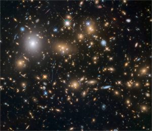 Hubble Frontier Fields image of the galaxy cluster MACS J07175+3745. Faint blue arcs are distant galaxies that have been magnified and distorted by the light-bending gravity of the massive cluster in front of them. The six clusters observed to unprecedented depth by the Frontier Fields program serve as natural gravitational telescopes, allowing Hubble to discover galaxies back into the first half billion years of cosmic history. Credit: NASA, ESA and the HST Frontier Fields team (STScI). 